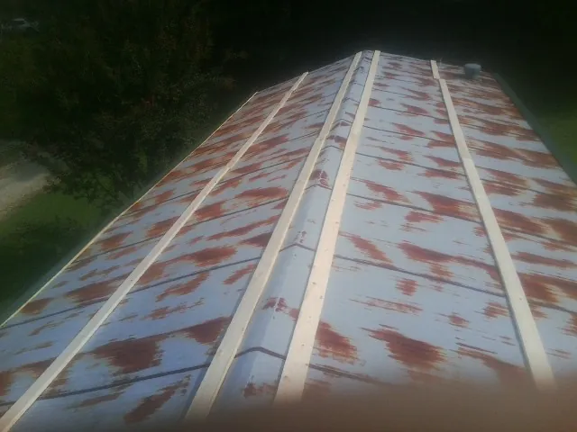 Rusted metal roof panels with new wood purlins before replacement — Storm Damage Roof Repair in Hill Afb by Roofing Brothers