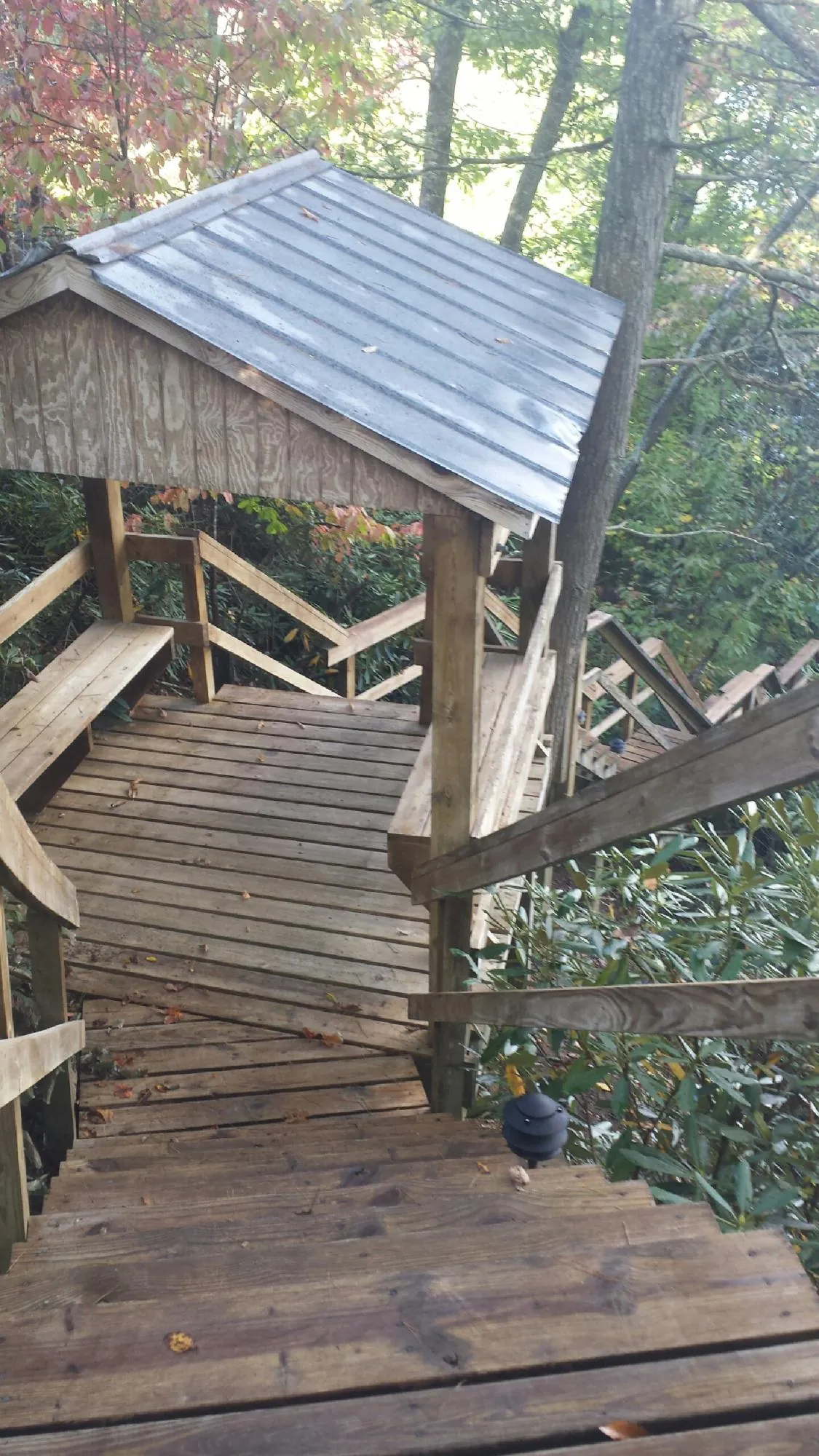 Metal roofed shelter over wooden steps on a wooded walkway — Skylight Repair & Installation work by our crew in Hill Afb