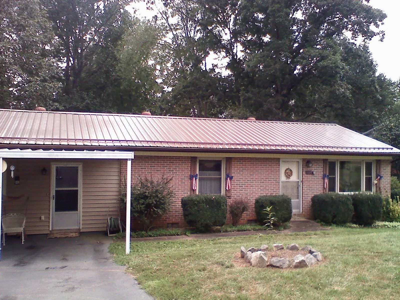 Bronze metal roof and carport on a brick ranch home — Roof Repair work by our crew in Hill Afb