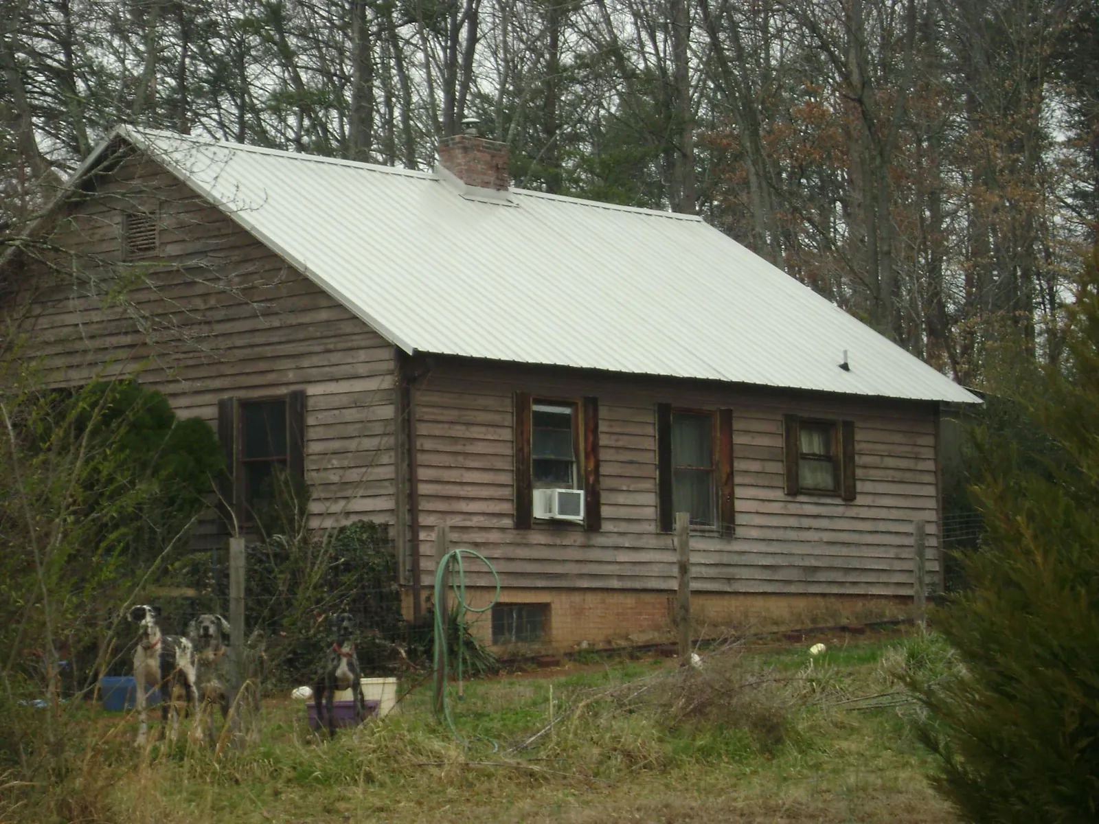 White metal roof on an old wood sided farmhouse, from a Asphalt Shingle Roof Repair job in Hill Afb